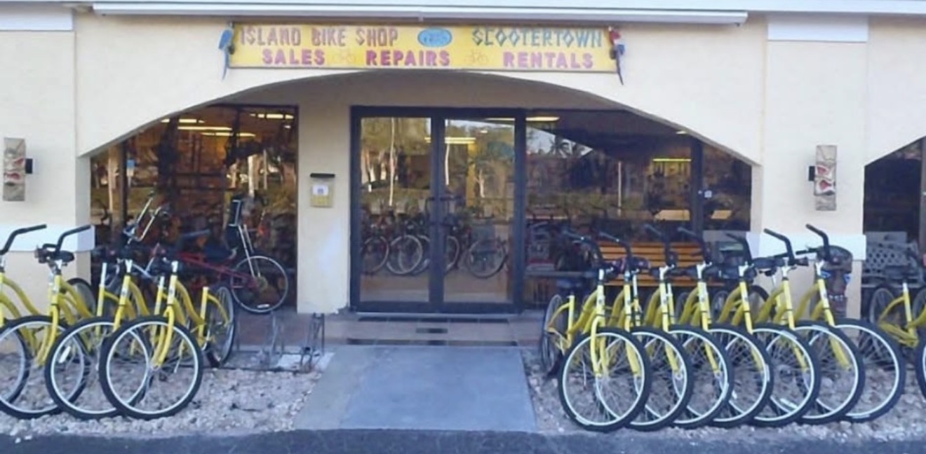 Island Bike Shop storefront on Marco Island, rows of yellow rental bikes lined up out front